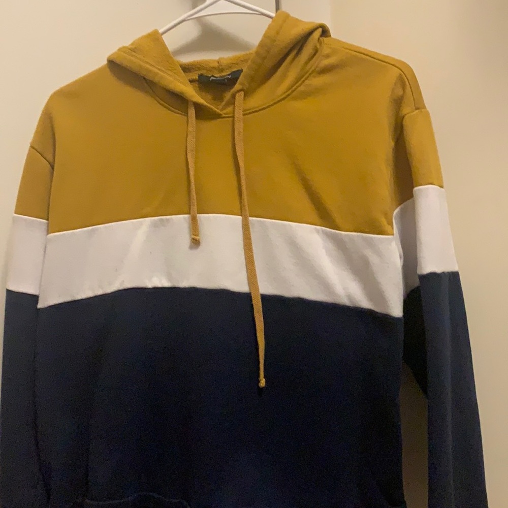 Colored tan, white, dark blue cropped hoodie.